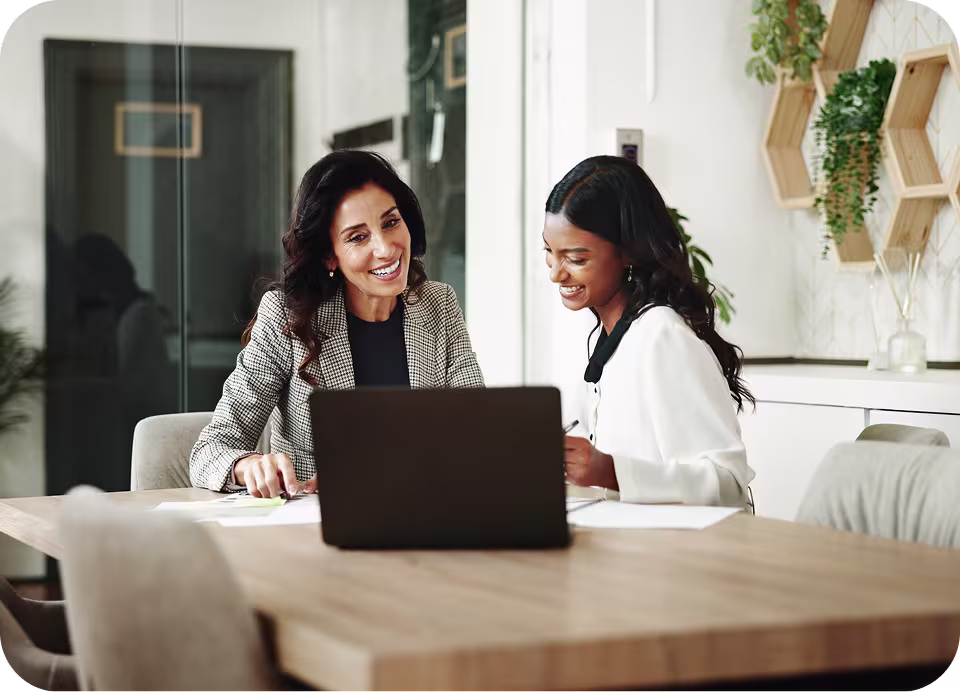 Two colleagues reviewing a practice's billing performance together at a laptop
