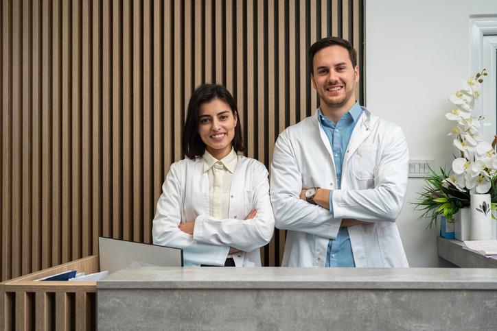 Two dermatology practice staff members at the front desk reception